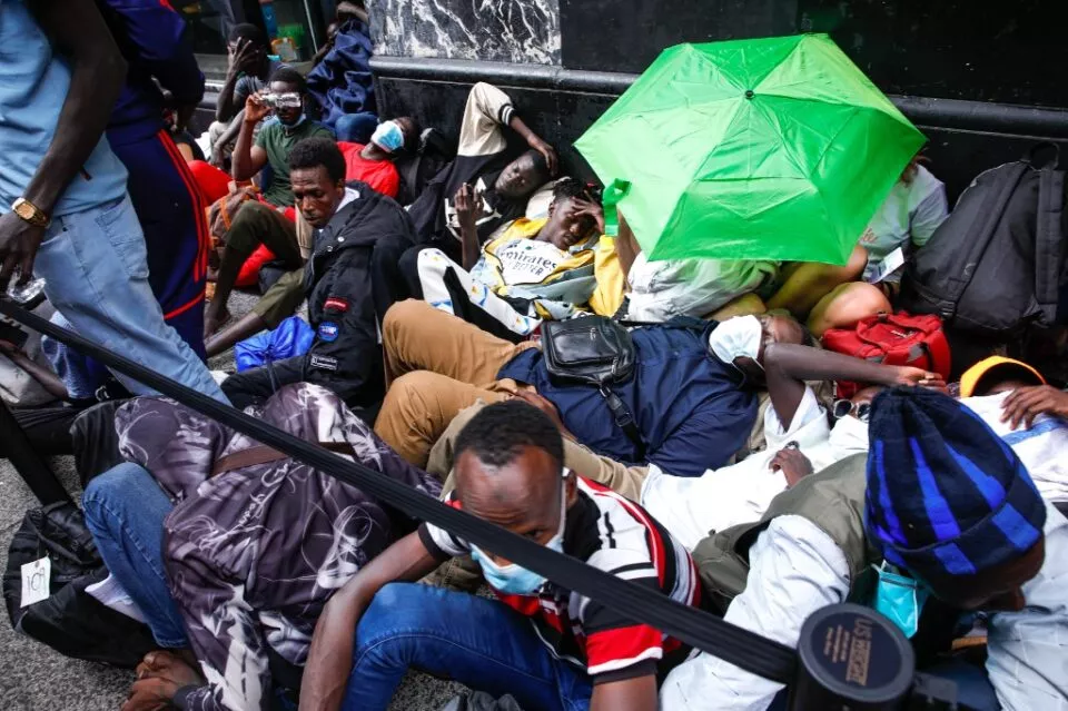 Migrants sleep outside the Roosevelt Hotel in midtown Manhattan, New York City, on July 31, 2023. Many newly arrived migrants have been waiting outside the Roosevelt Hotel, which has been turned into a migrant reception center, to try to secure temporary housing. (Photo by KENA BETANCUR / AFP)