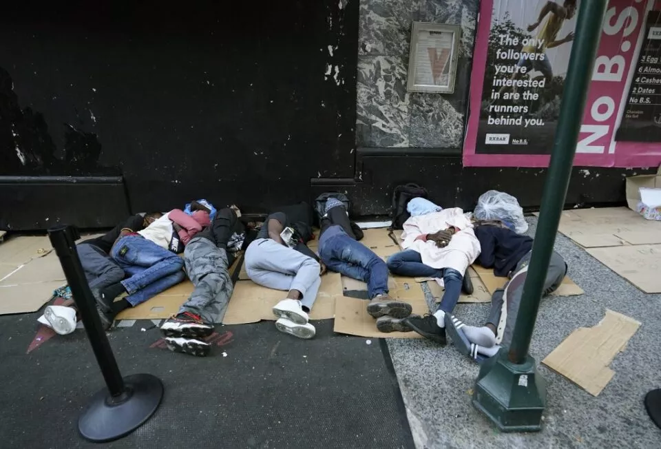 Migrants sleep outside the Roosevelt Hotel as they wait for placement at the hotel in New York on August 1, 2023. Many newly arrived migrants have been waiting outside the Roosevelt Hotel, which has been turned into a migrant reception center, to try to secure temporary housing. (Photo by TIMOTHY A. CLARY / AFP)